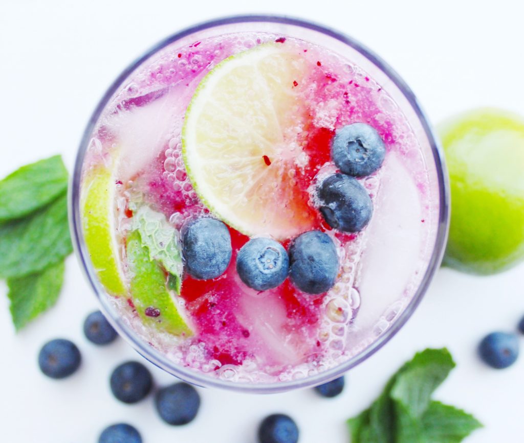 Overhead shot of blueberry lime mocktail with lime, mint and blueberries on top 