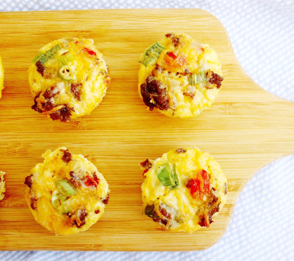Egg cups on a wooden cutting board