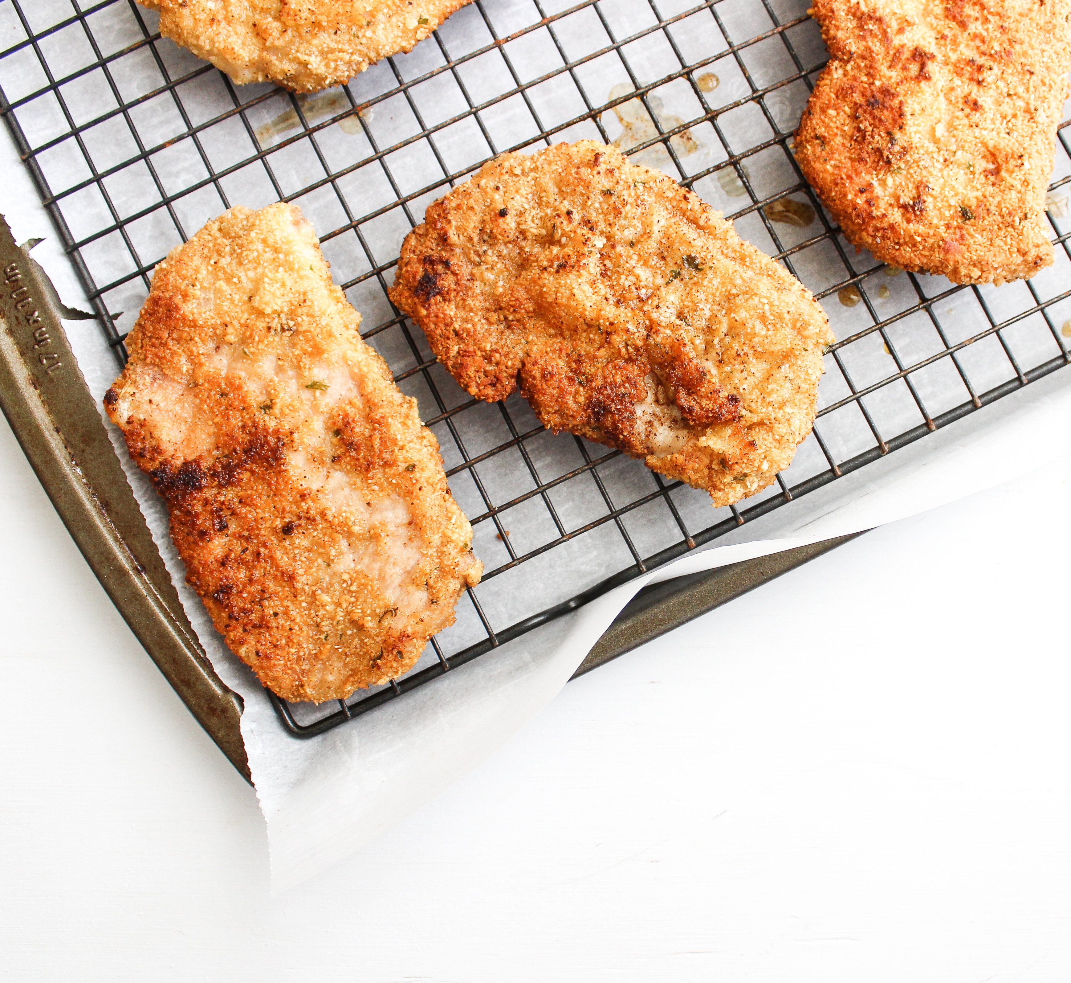 crispy breaded pork cutlets sitting on a baking rack