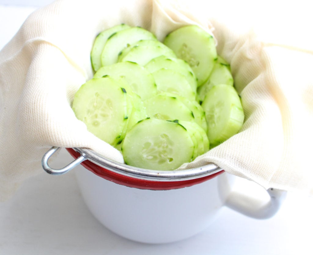 Thinly sliced cucumbers in a strainer