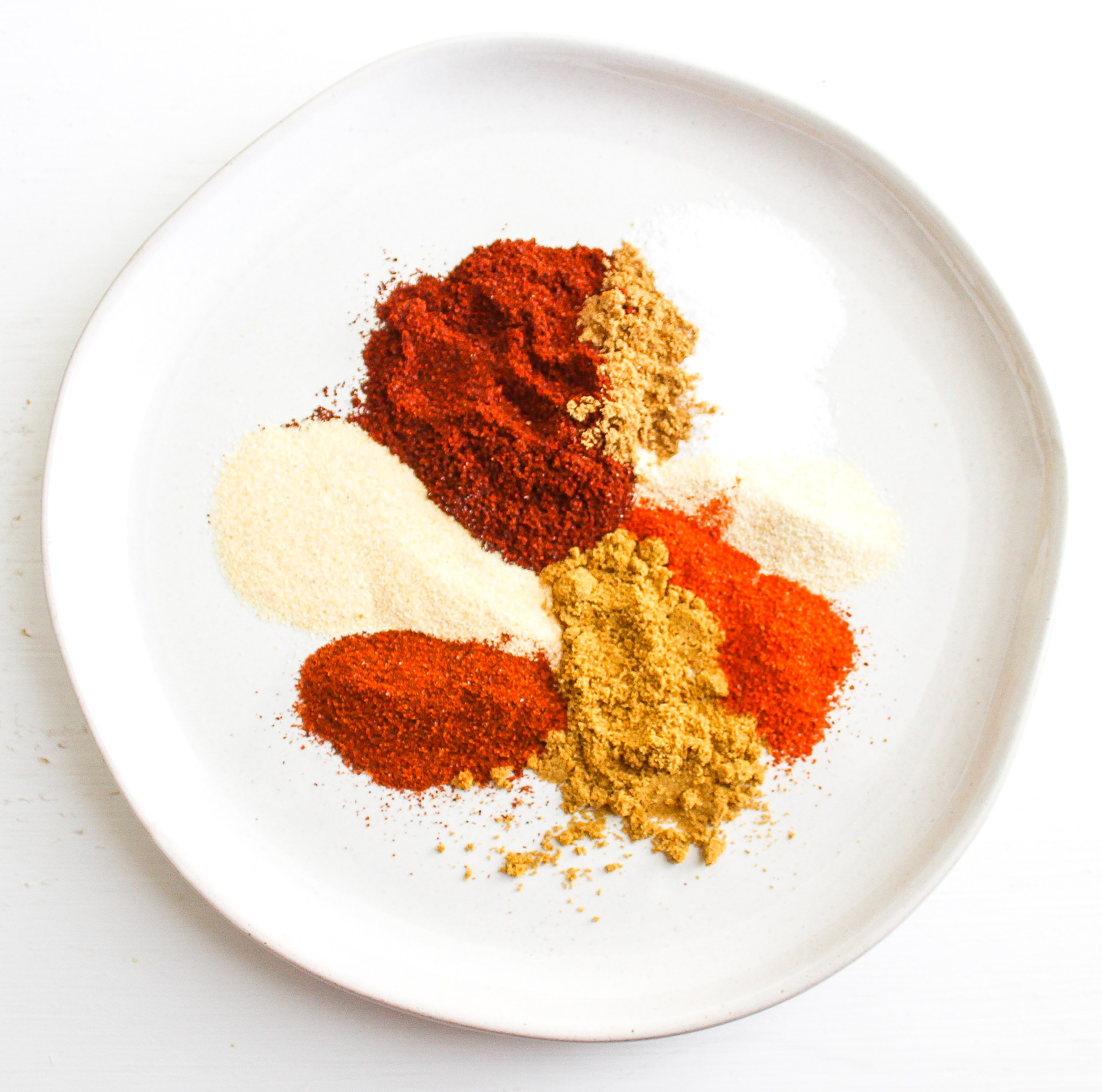 Assortment of herbs and spices on a white plate 