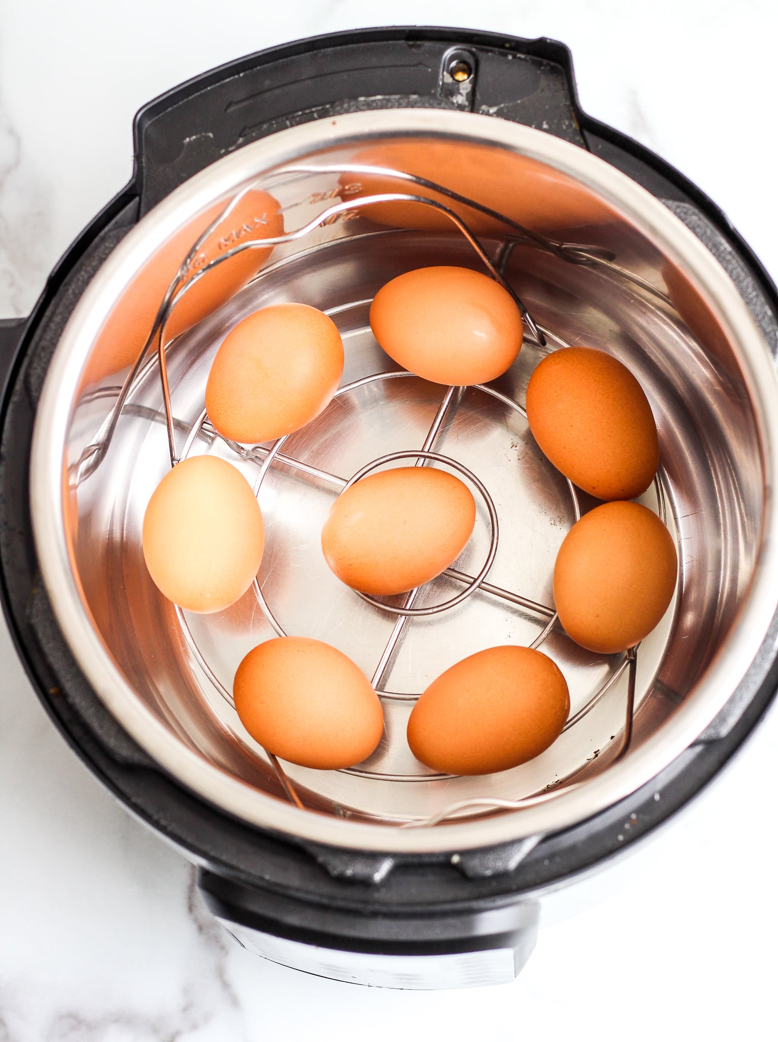 brown eggs layered in the bottom of an Instant Pot 
