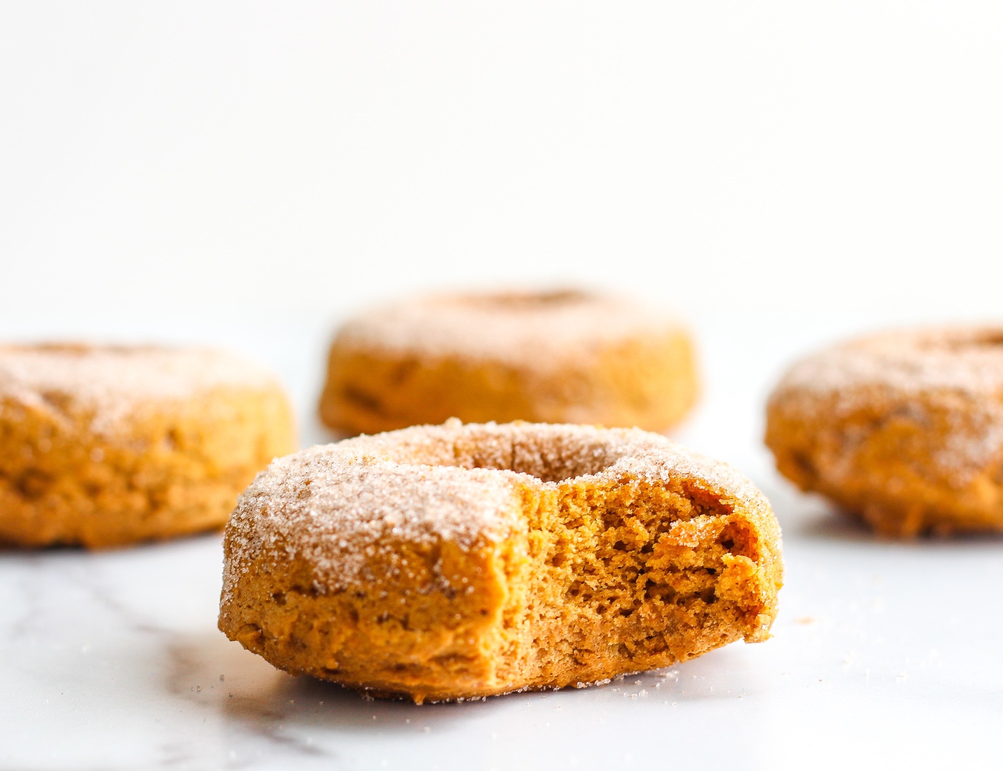 Gluten Free Pumpkin Spiced Donut with a bite taken out of it 