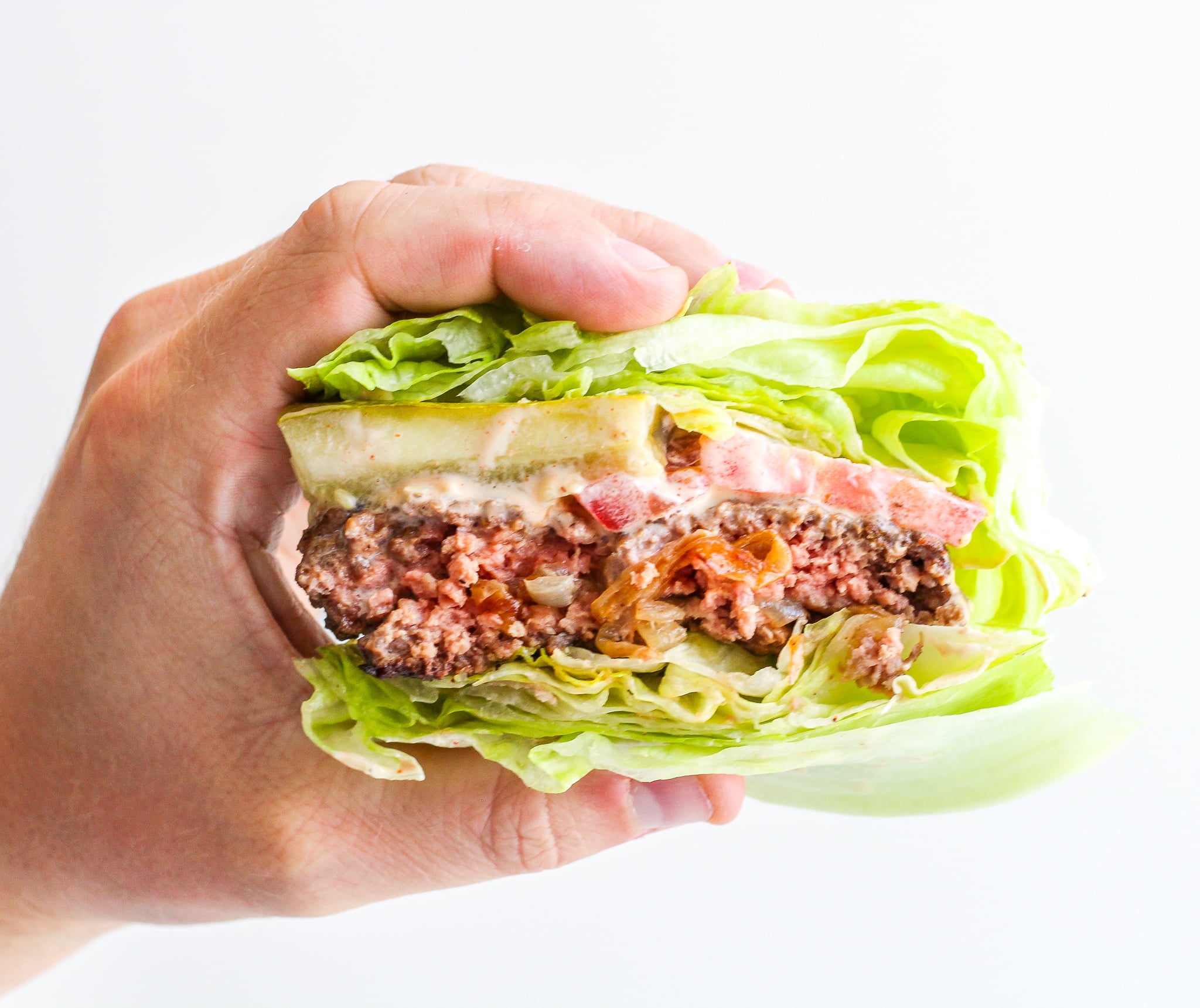 Caramelized Onion Stuffed Burgers hand holding a Caramelized Onion Stuffed Burger