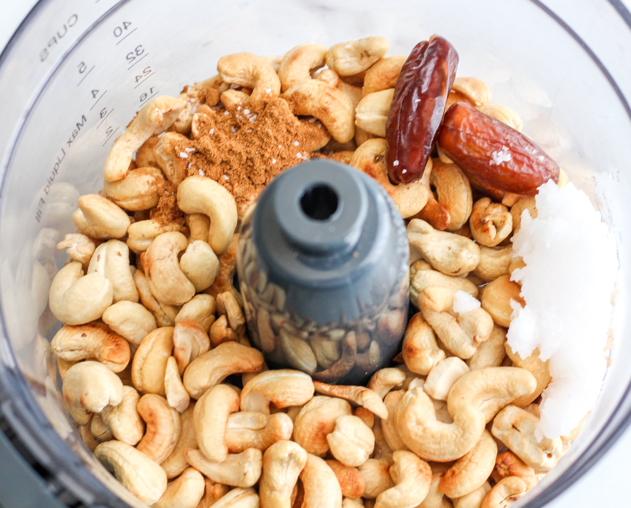 food processor with roasted cashews, dates, pumpkin pie spice, coconut oil and salt