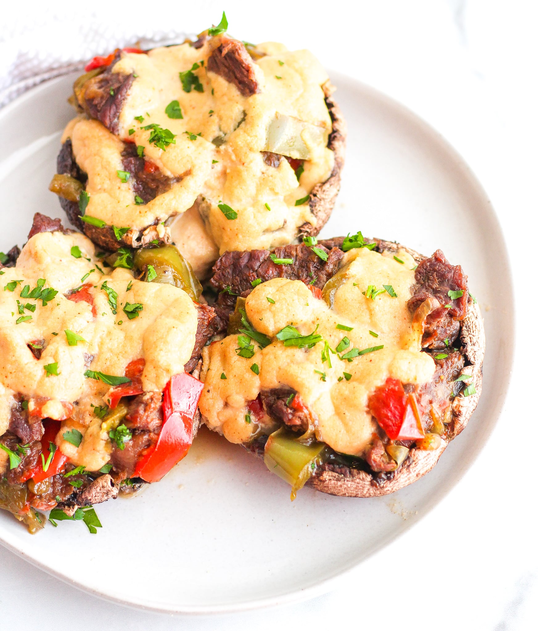 Portobello mushrooms stuffed with steak and peppers, topped with a cashew cream sauce 