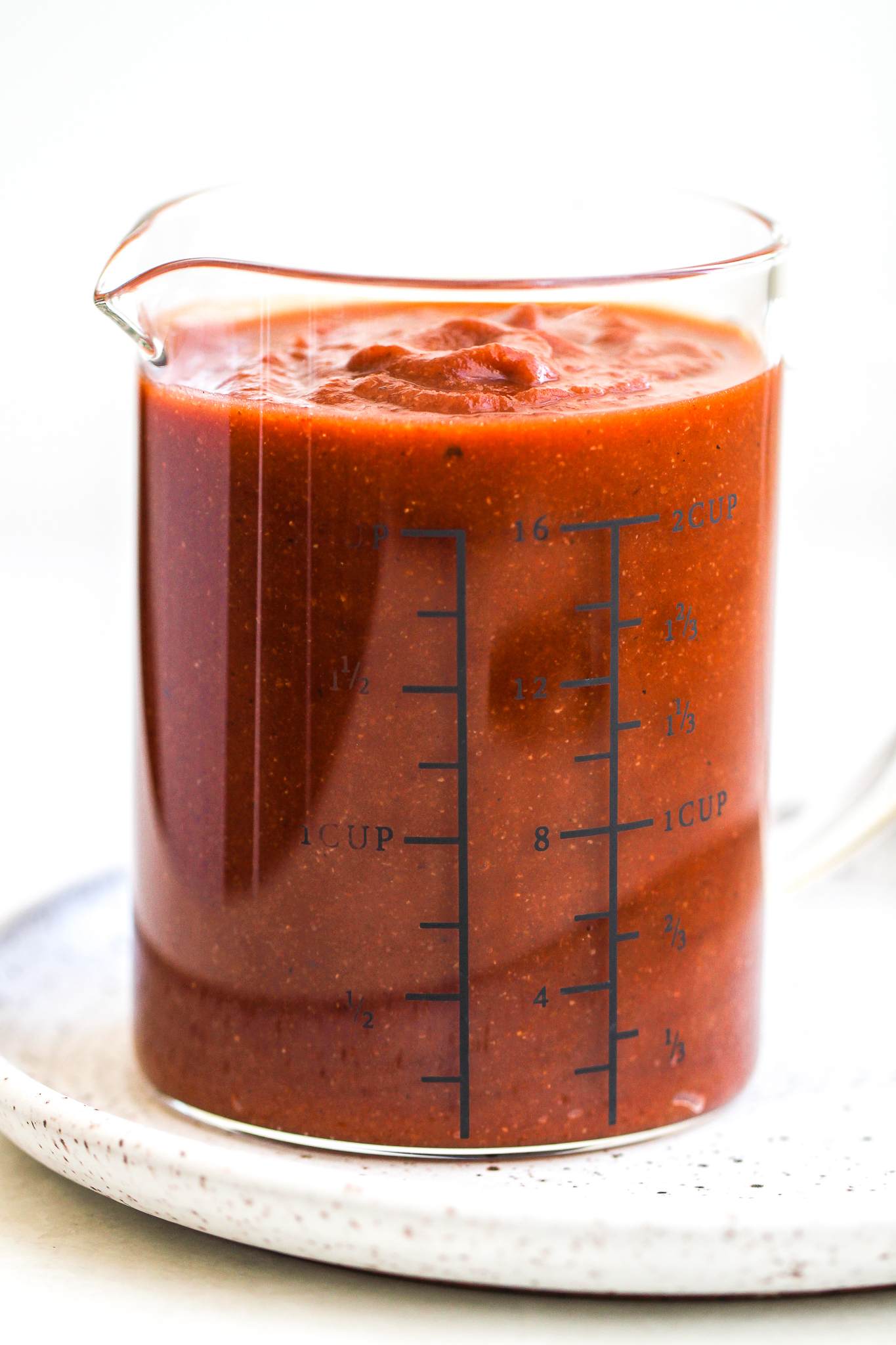 glass measuring cup filled with sweet & tangy Paleo BBQ sauce 