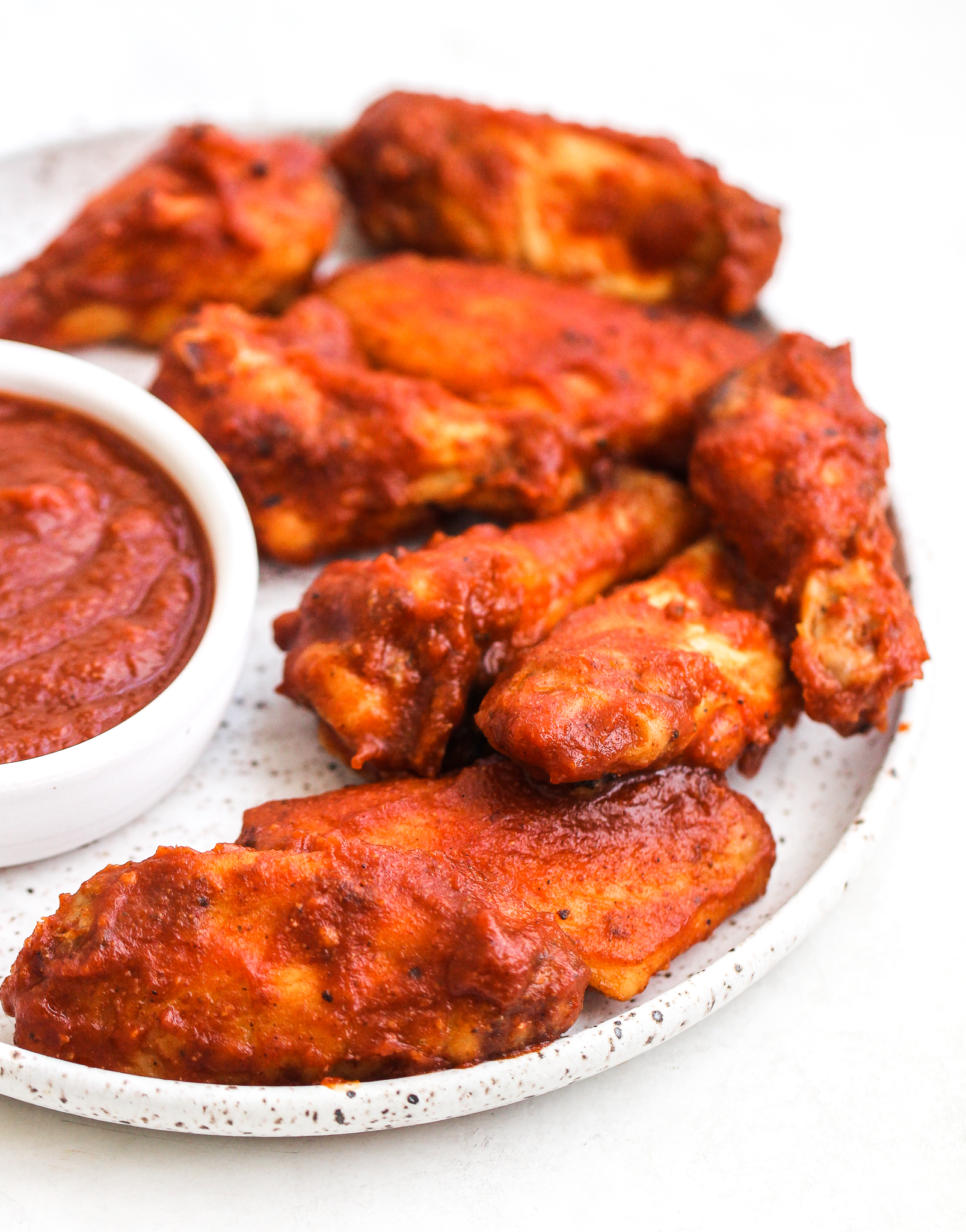 BBQ chicken wings on a speckled ceramic plate 