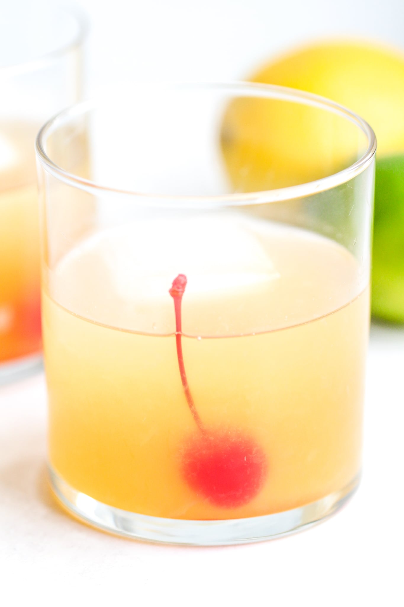 clear cocktail glass filled with a classic whiskey sour and a maraschino cherry inside 