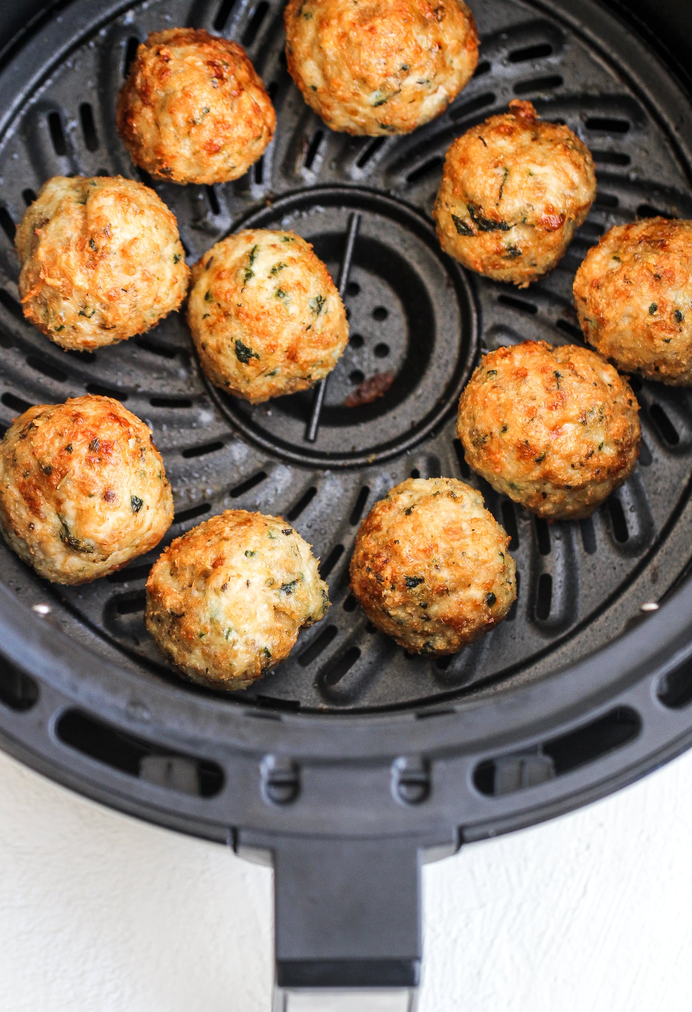 chicken parmesan meatballs in an air fryer basket 