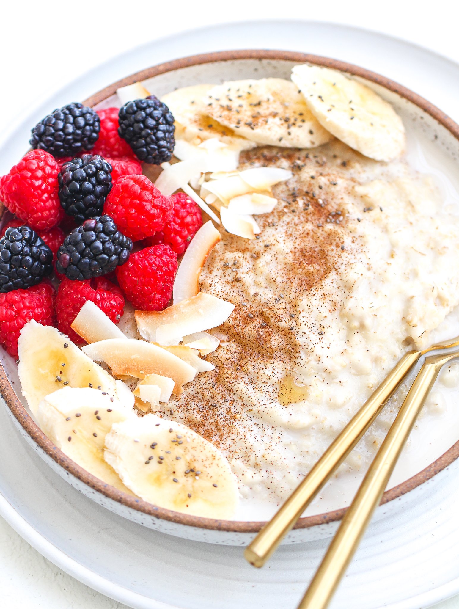 instant pot oatmeal in a ceramic bowl with toppings and spoons in it