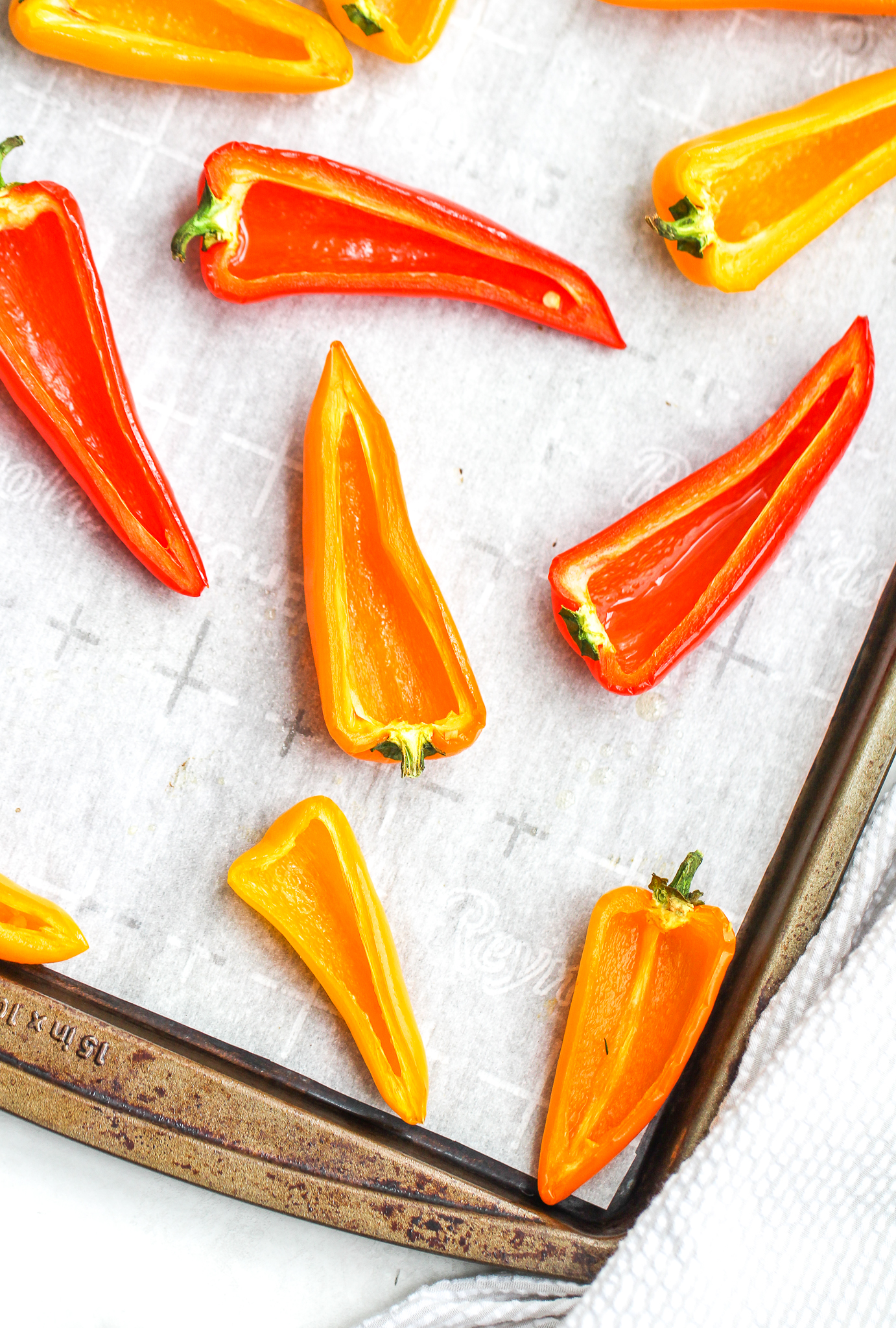 sliced sweet peppers on a parchment lined baking sheet 