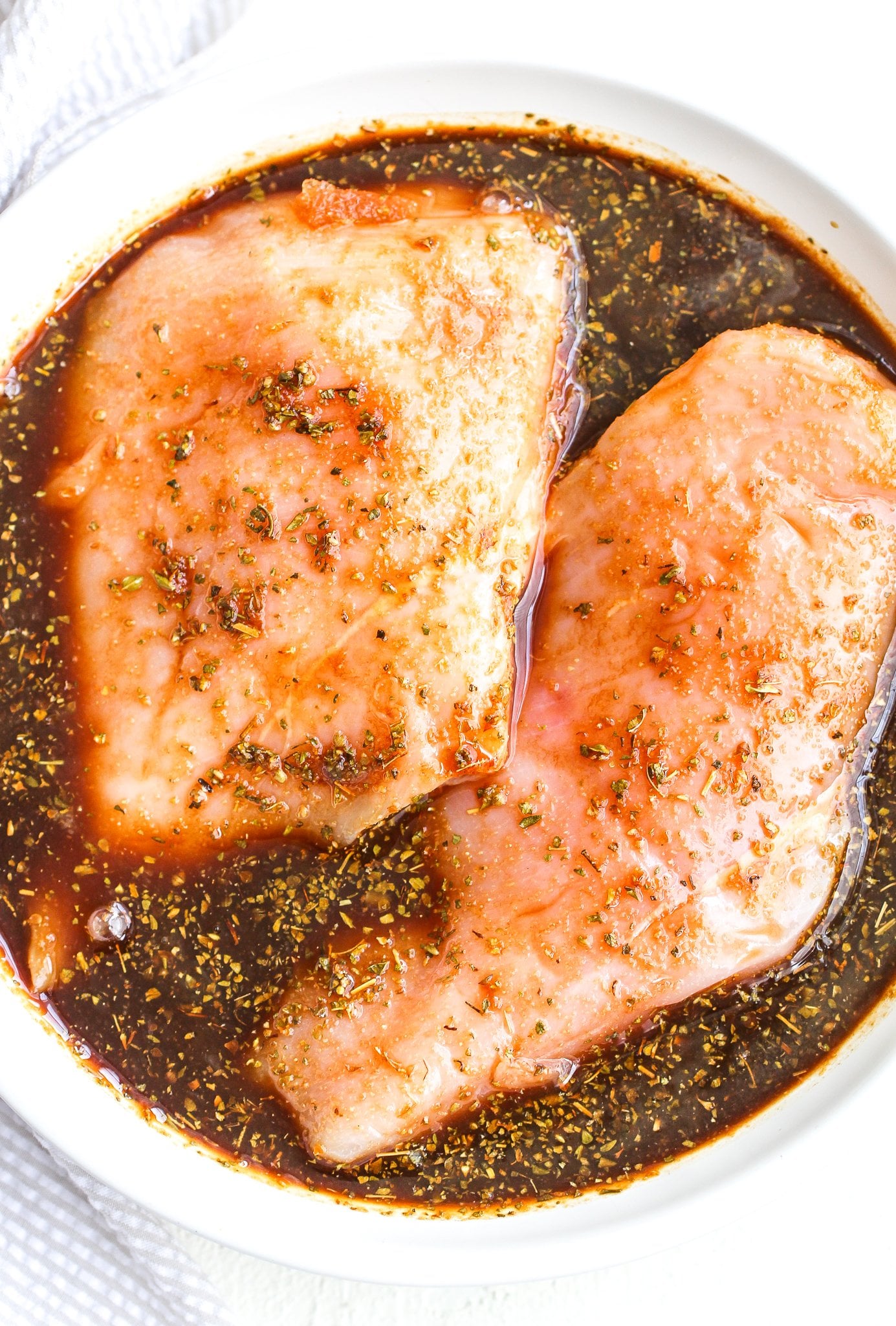 raw chicken breasts sitting in balsamic marinade 