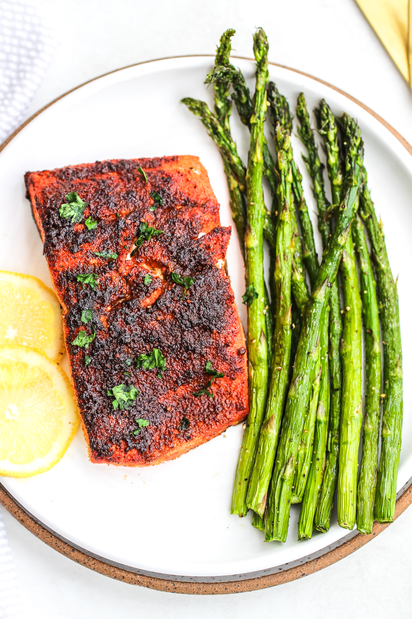 air fryer asparagus on a ceramic plate with air fryer salmon and lemon slices 