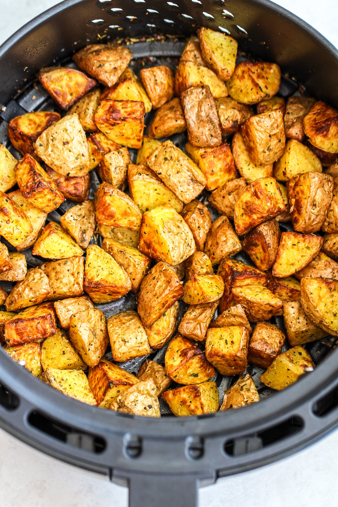 crispy potatoes in an air fryer basket 
