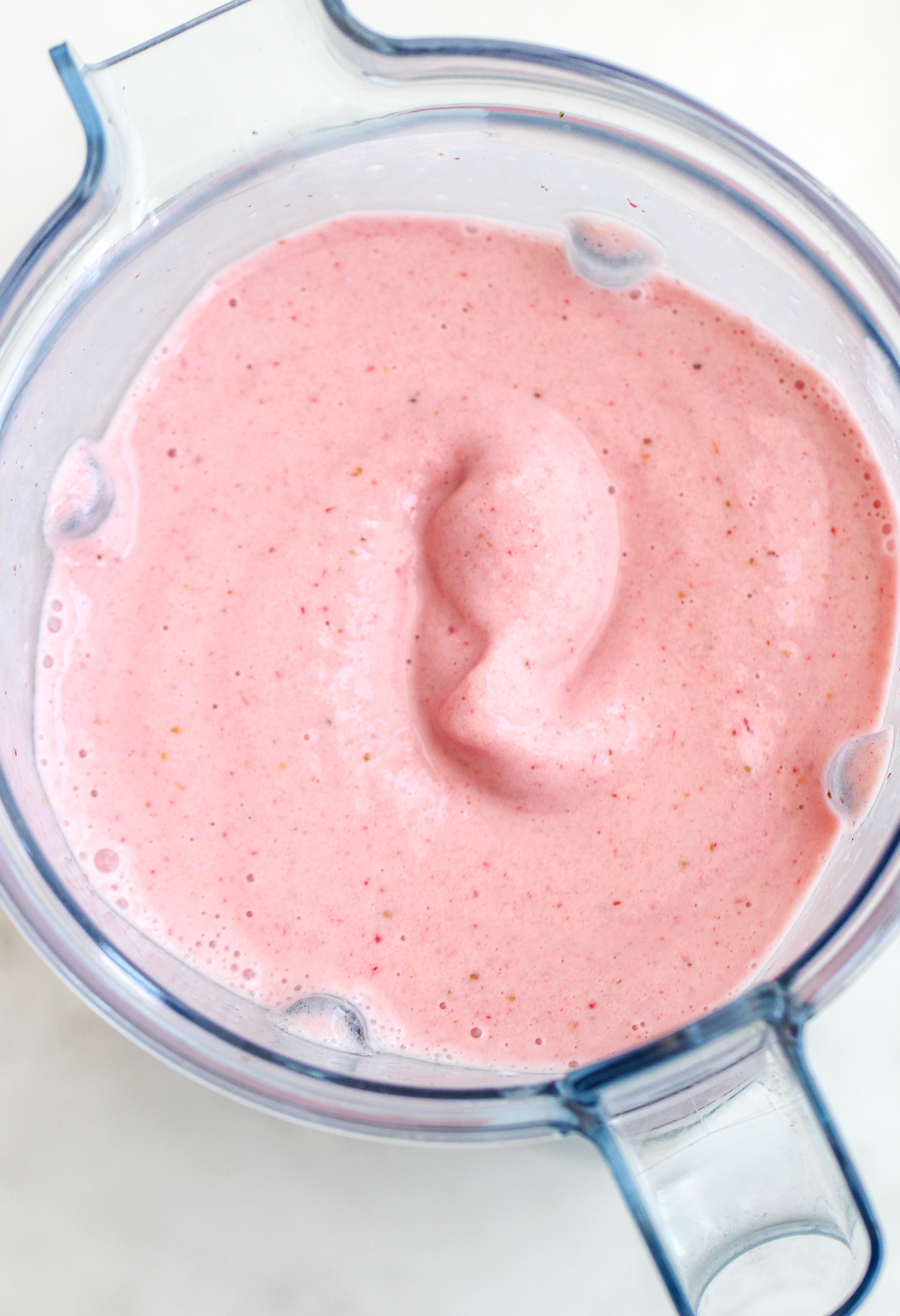 creamy pink strawberry banana smoothie in a blender 