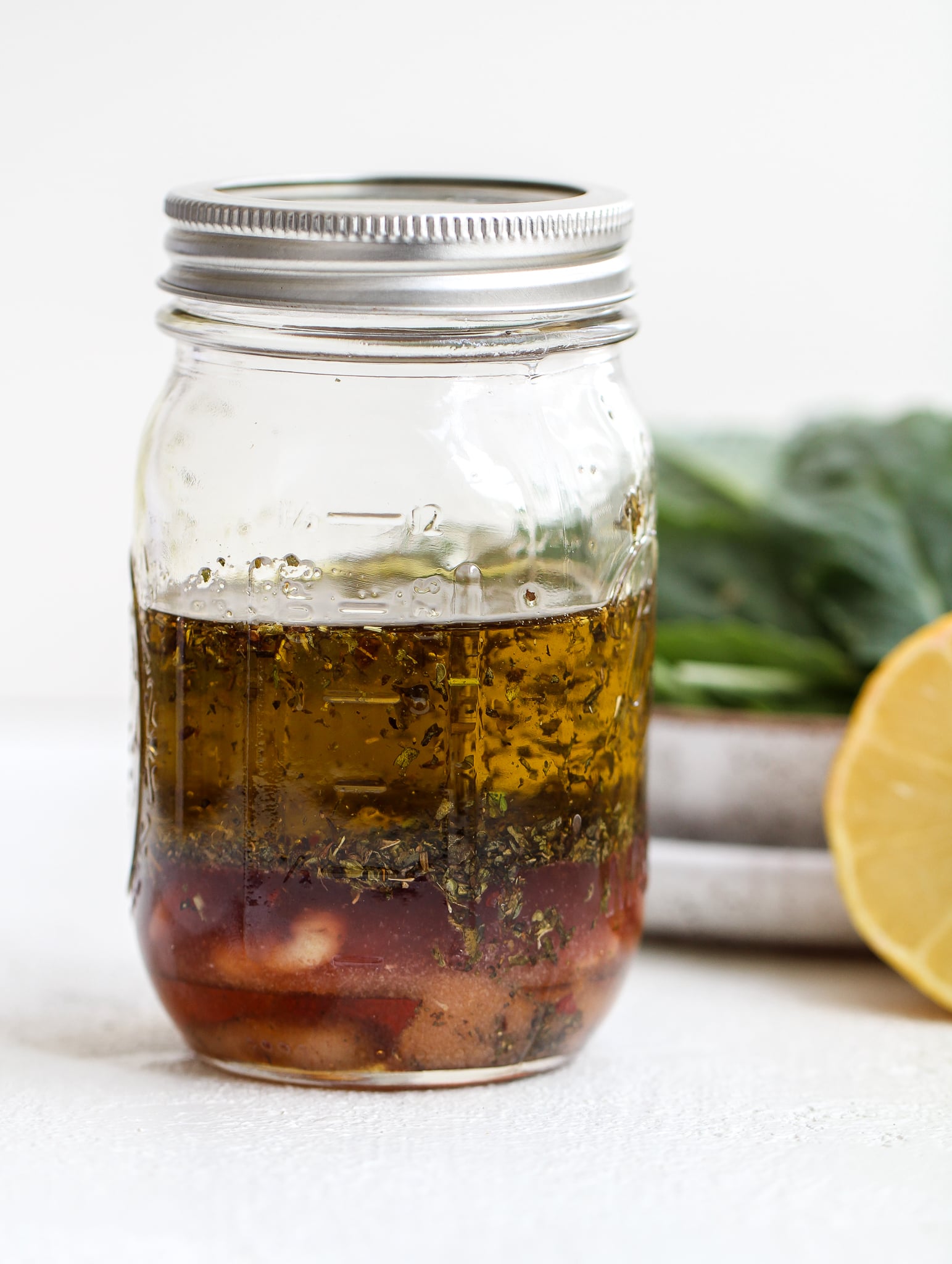 ingredients for italian dressing in a clear glass mason jar before it gets shaken up 