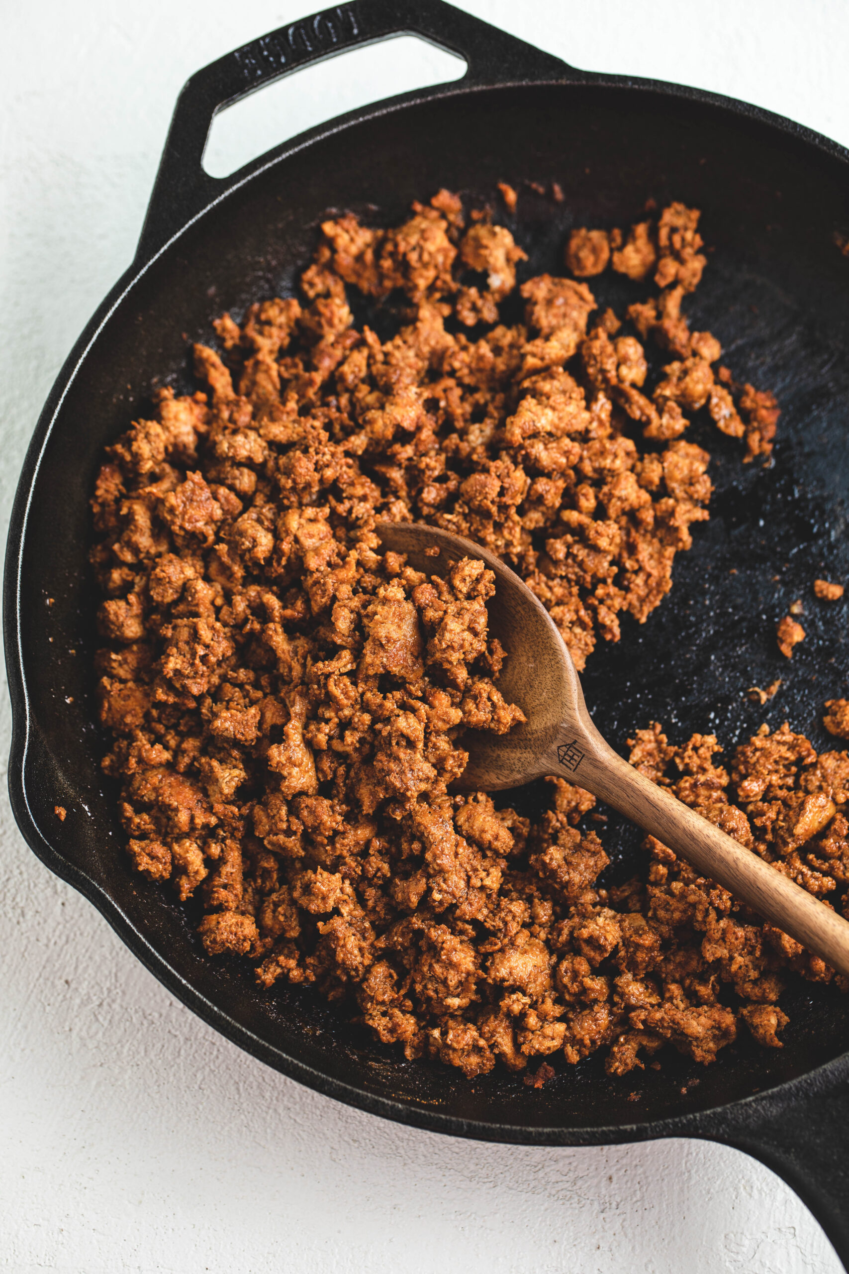 Cooked ground turkey in a cast iron skillet, it is seasoned with taco seasoning. 
