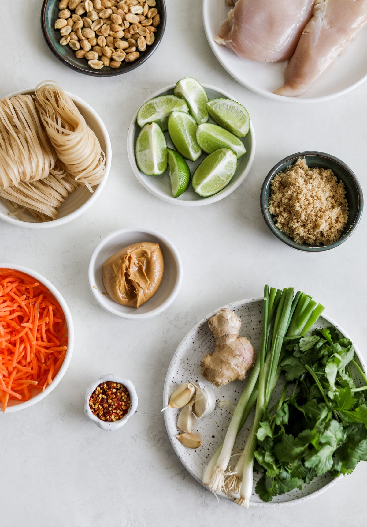 ingredients of Instant Pot Pad Thai laid out on a table in a variety of serving bowls and plates