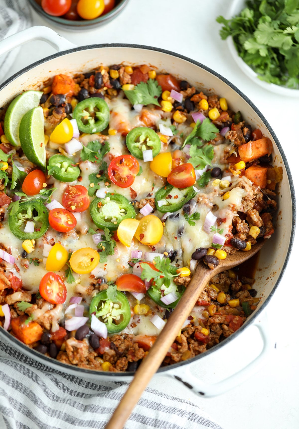 healthy turkey taco skillet with a wooden serving spoon scooping out a portion.